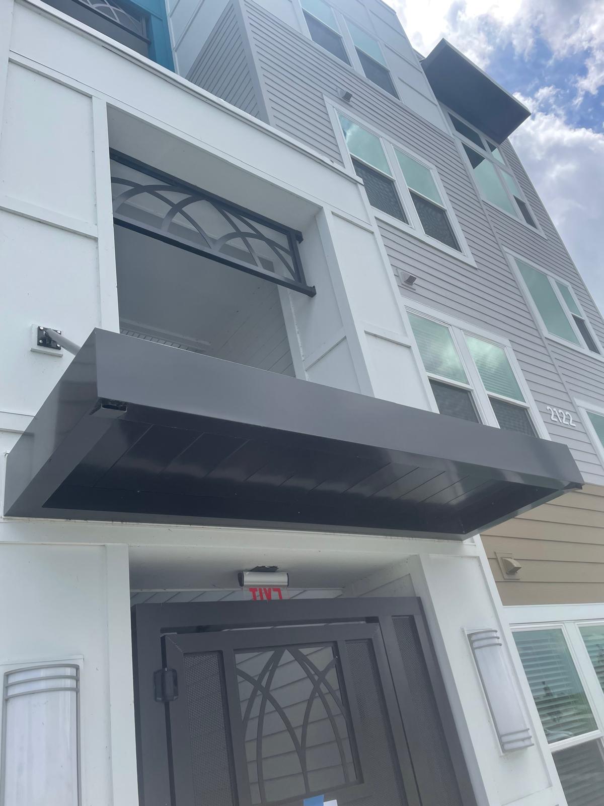 Modern steel entry canopy on residential development