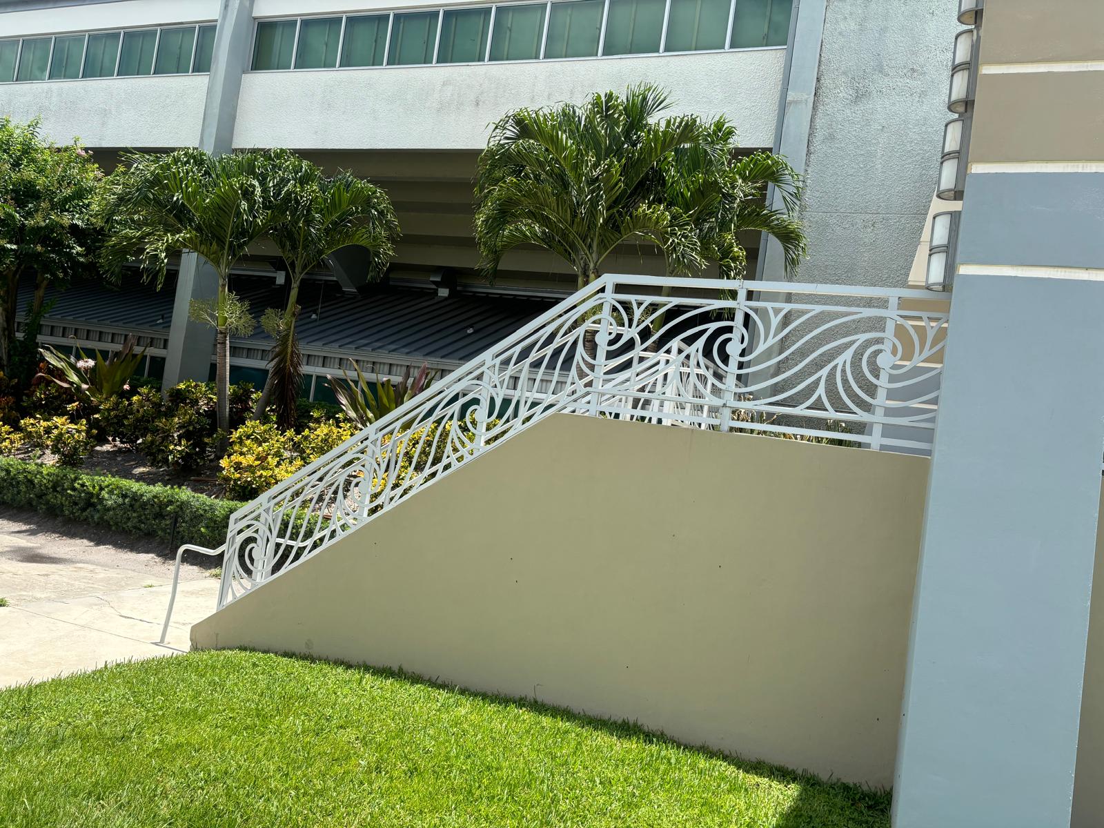 Decorative white railing with wave pattern on commercial staircase